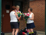 Two women next to eachother holding flowers