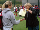 A woman being handed a laminated award