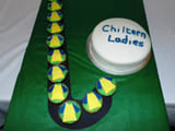 A green cake with a edible hockey stick on it